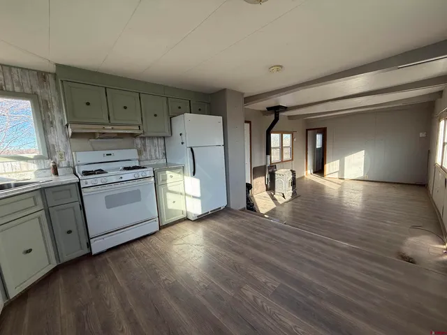 a kitchen with cabinets and wooden floor