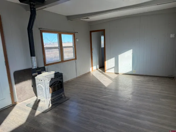 a view of a livingroom with wooden floor and furniture