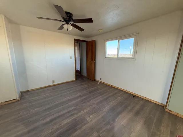 a view of a livingroom with a ceiling fan & wooden floor