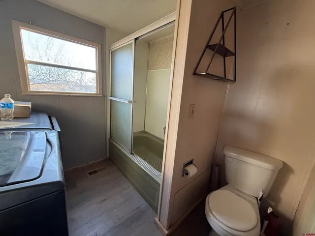 a bathroom with a toilet and a shower