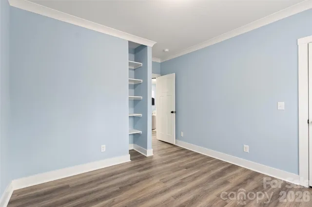 a view of empty room with wooden floor