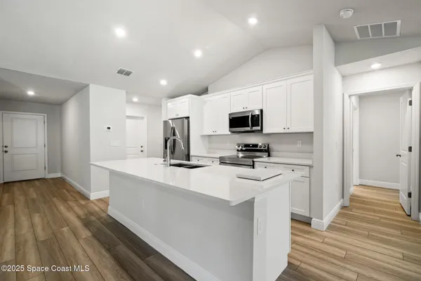 a kitchen with stainless steel appliances a refrigerator stove microwave and sink