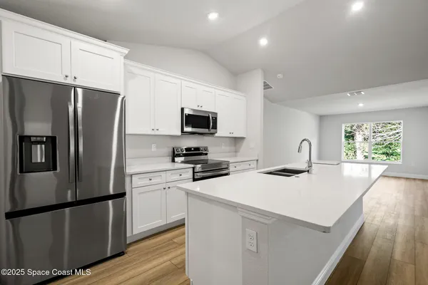 a kitchen with a sink and a stove top oven