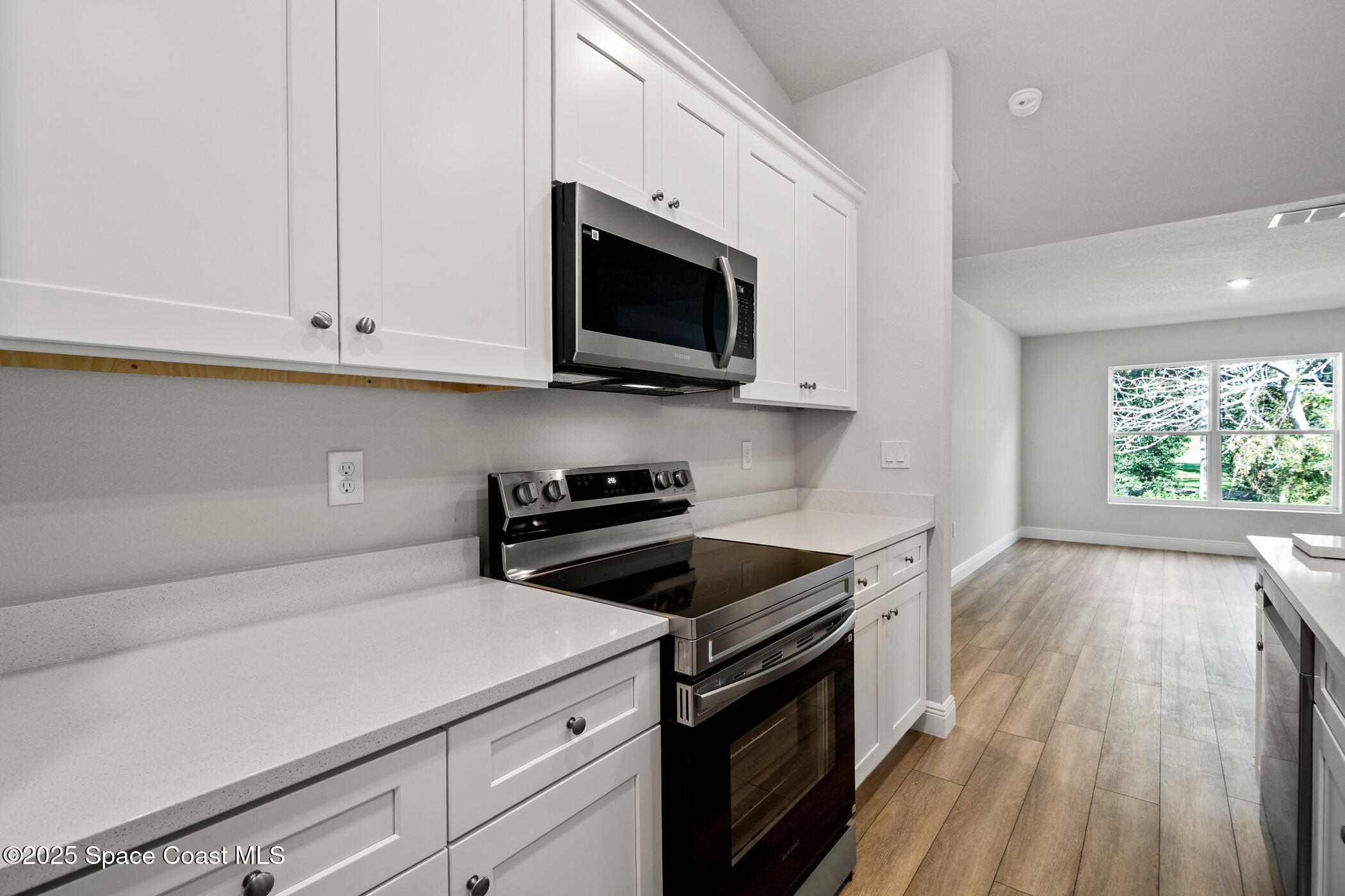 5435 Southeast 91st Street Ocala, FL 34480 - Photo 17 of 44 a kitchen with stainless steel appliances a stove a microwave a sink and cabinets