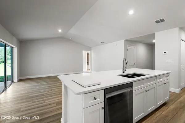 an empty room with wooden floor and window