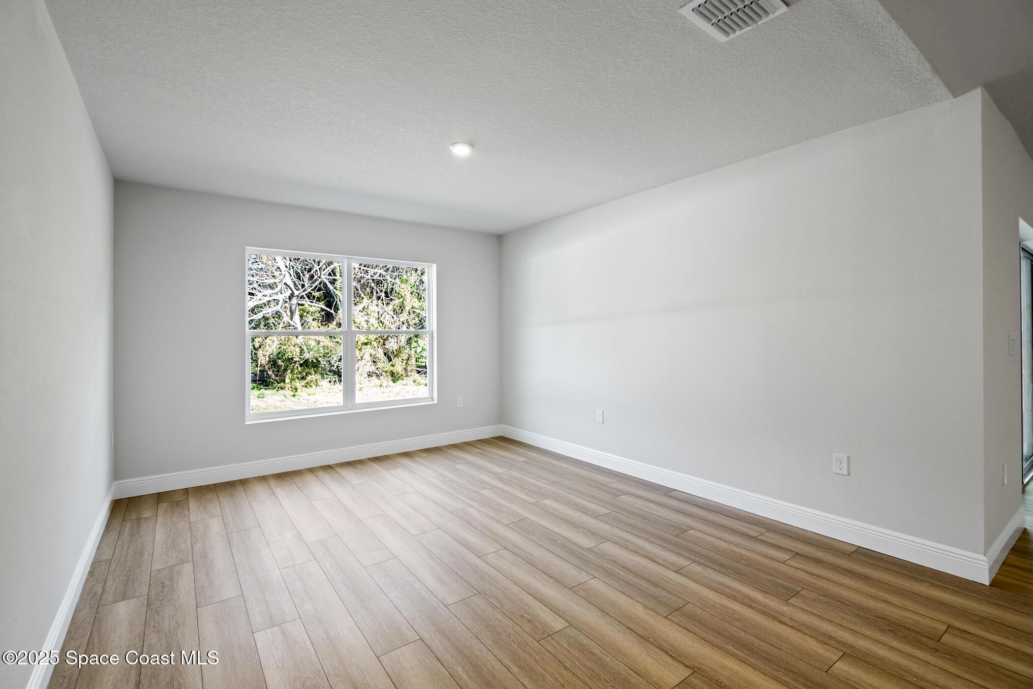 5435 Southeast 91st Street Ocala, FL 34480 - Photo 19 of 44 an empty room with wooden floor and window