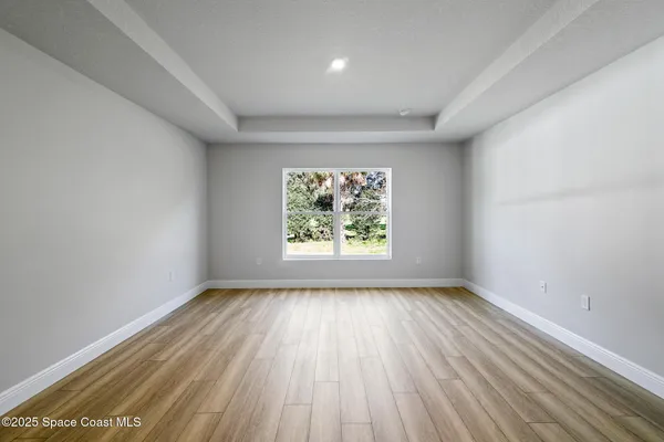 wooden floor in an empty room with a window