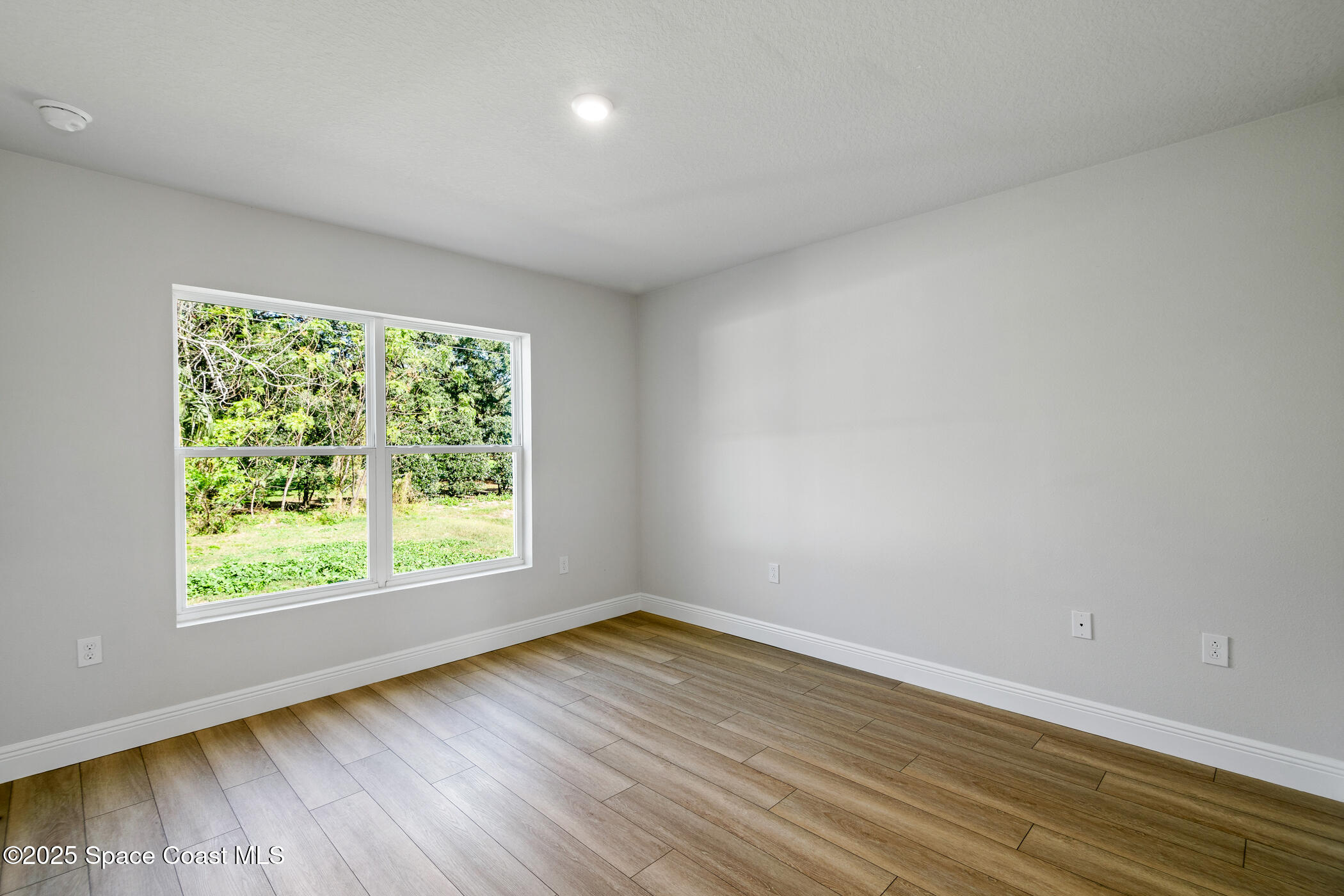 5435 Southeast 91st Street Ocala, FL 34480 - Photo 29 of 44 a view of an empty room with wooden floor and a window