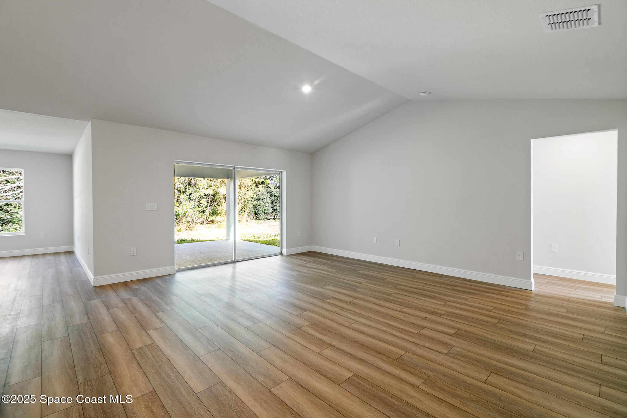 5435 Southeast 91st Street Ocala, FL 34480 - Photo 8 of 44 a view of an empty room with wooden floor and a window