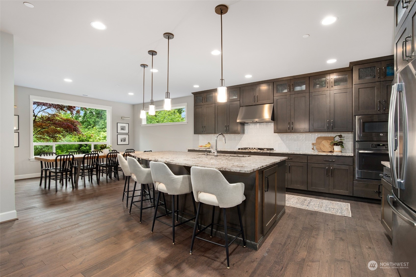 1607 233rd Street Southeast Bothell, WA 98021 - Photo 12 of 40 a kitchen with stainless steel appliances granite countertop a stove a refrigerator a kitchen island a dining table and chairs
