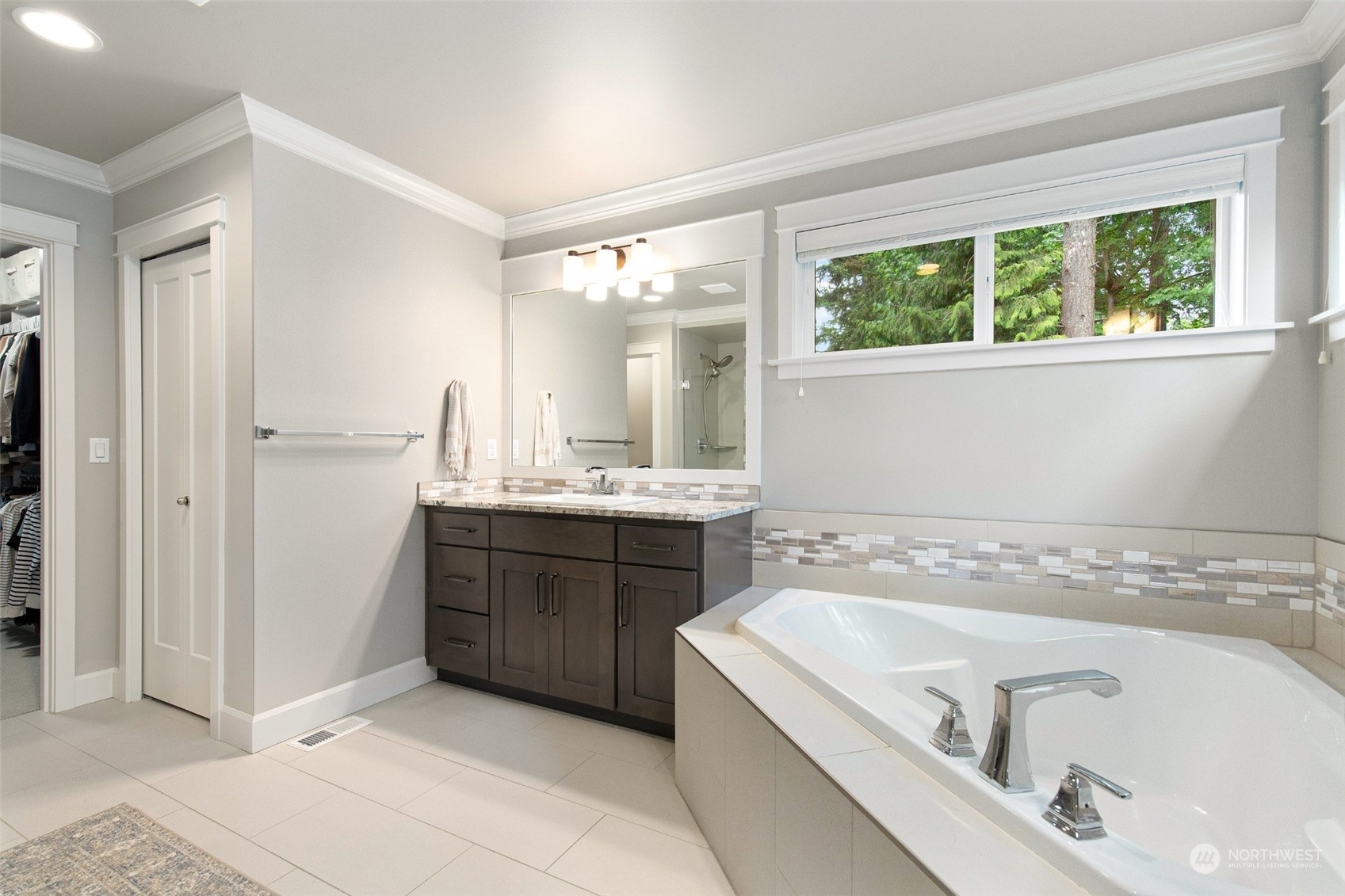 1607 233rd Street Southeast Bothell, WA 98021 - Photo 22 of 40 a bathroom with a tub a sink a mirror and a shower