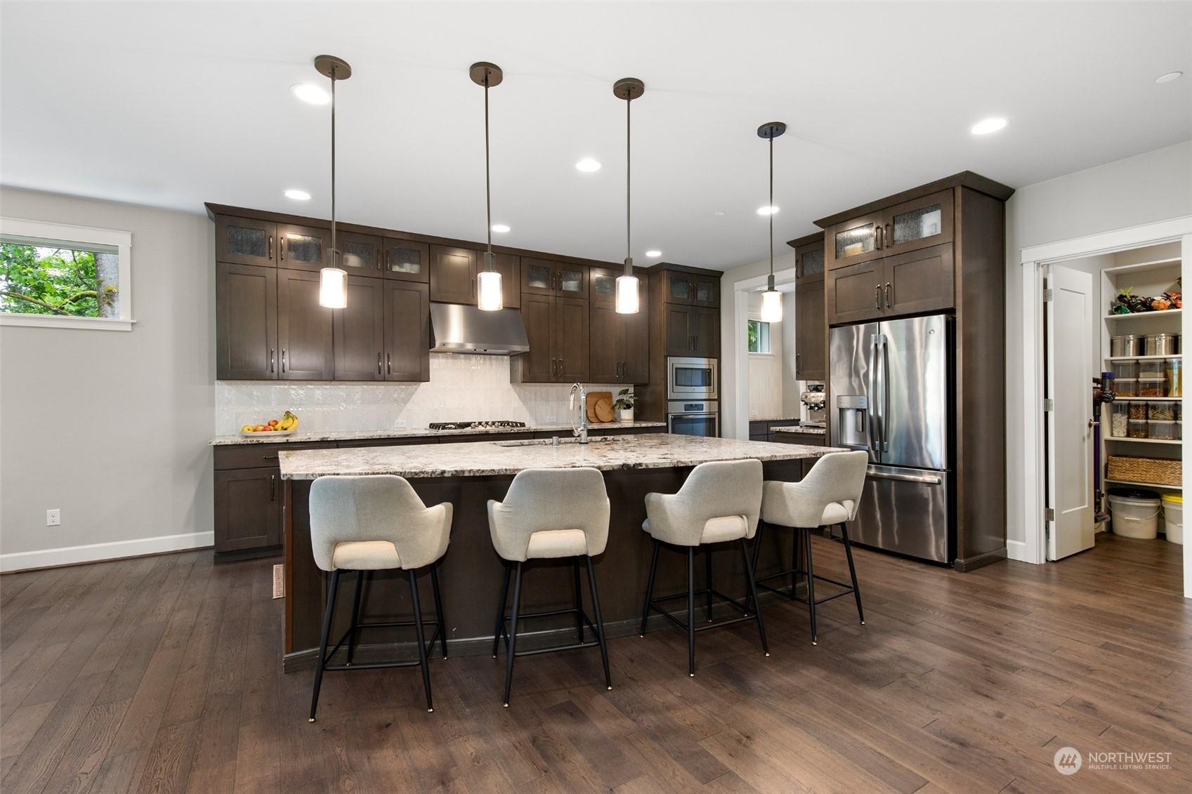 1607 233rd Street Southeast Bothell, WA 98021 - Photo 7 of 40 a view of a kitchen with stainless steel appliances kitchen island granite countertop a table chairs sink and cabinets