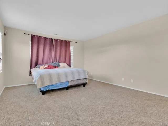 an empty room with windows and ceiling fan