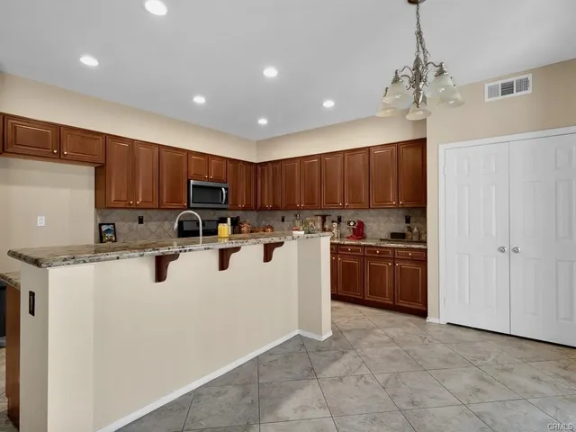 a kitchen with stainless steel appliances granite countertop a refrigerator and a stove top oven