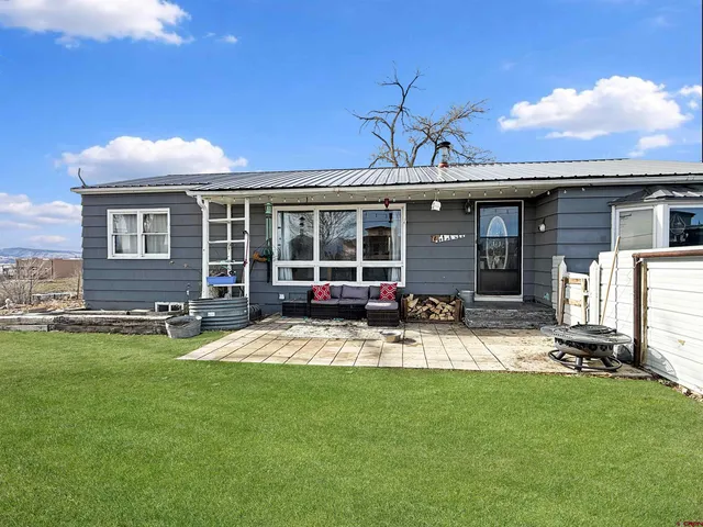 a view of a house with a backyard and a patio