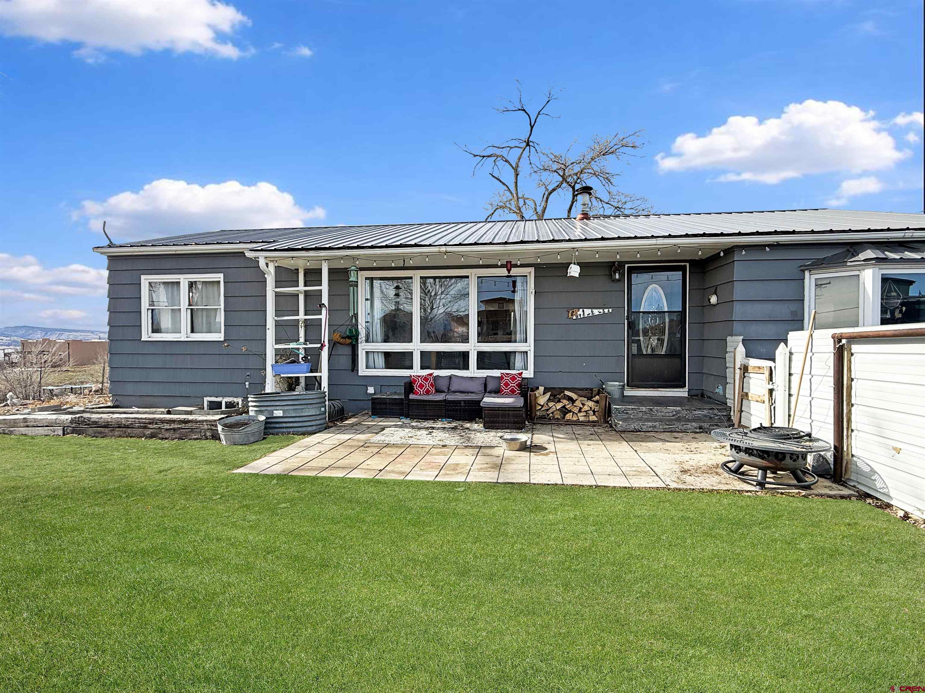 a view of a house with a backyard and a patio