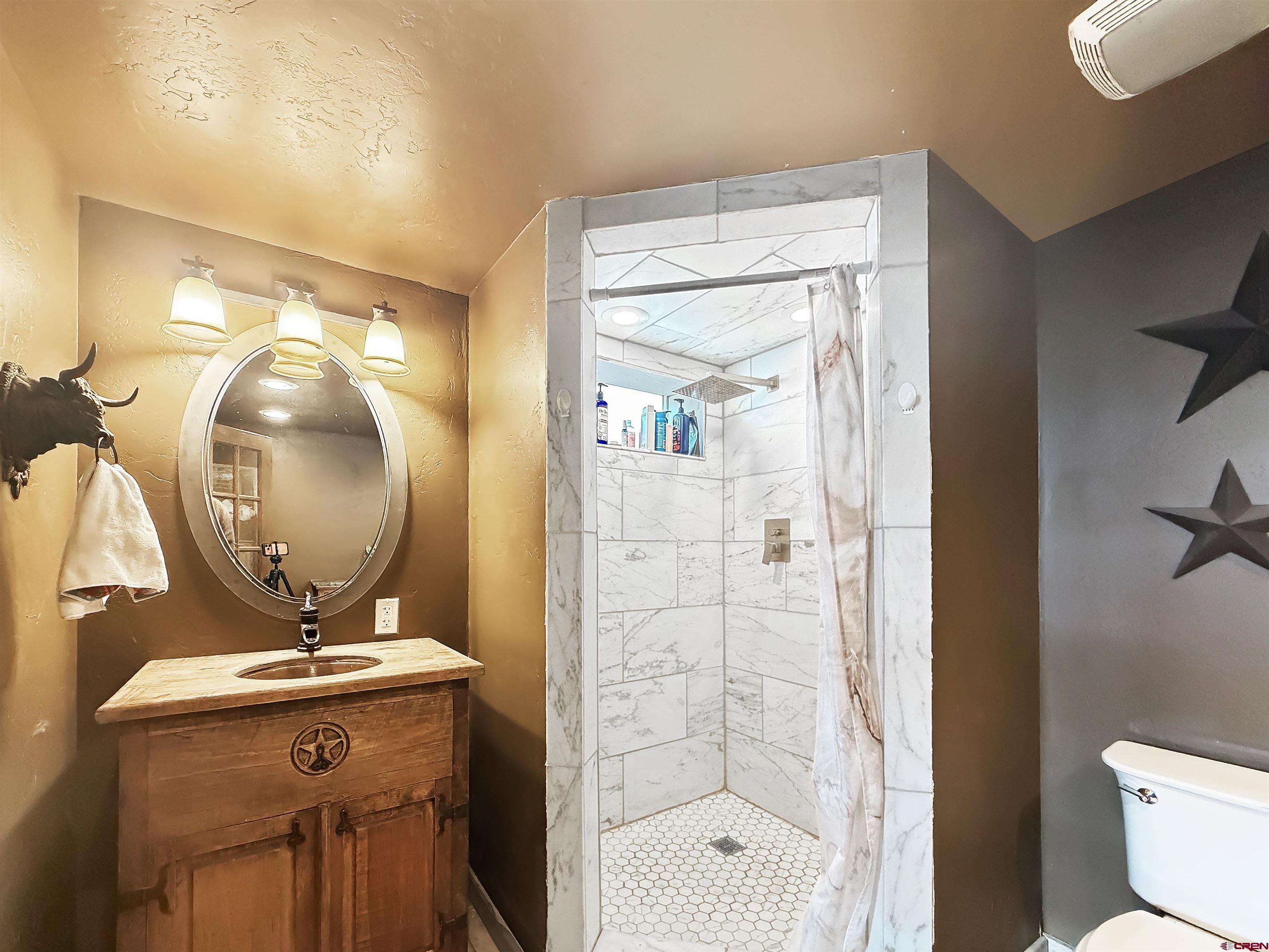 10659 3100th Road Hotchkiss, CO 81419 - Photo 29 of 40 a bathroom with a sink a mirror and a shower