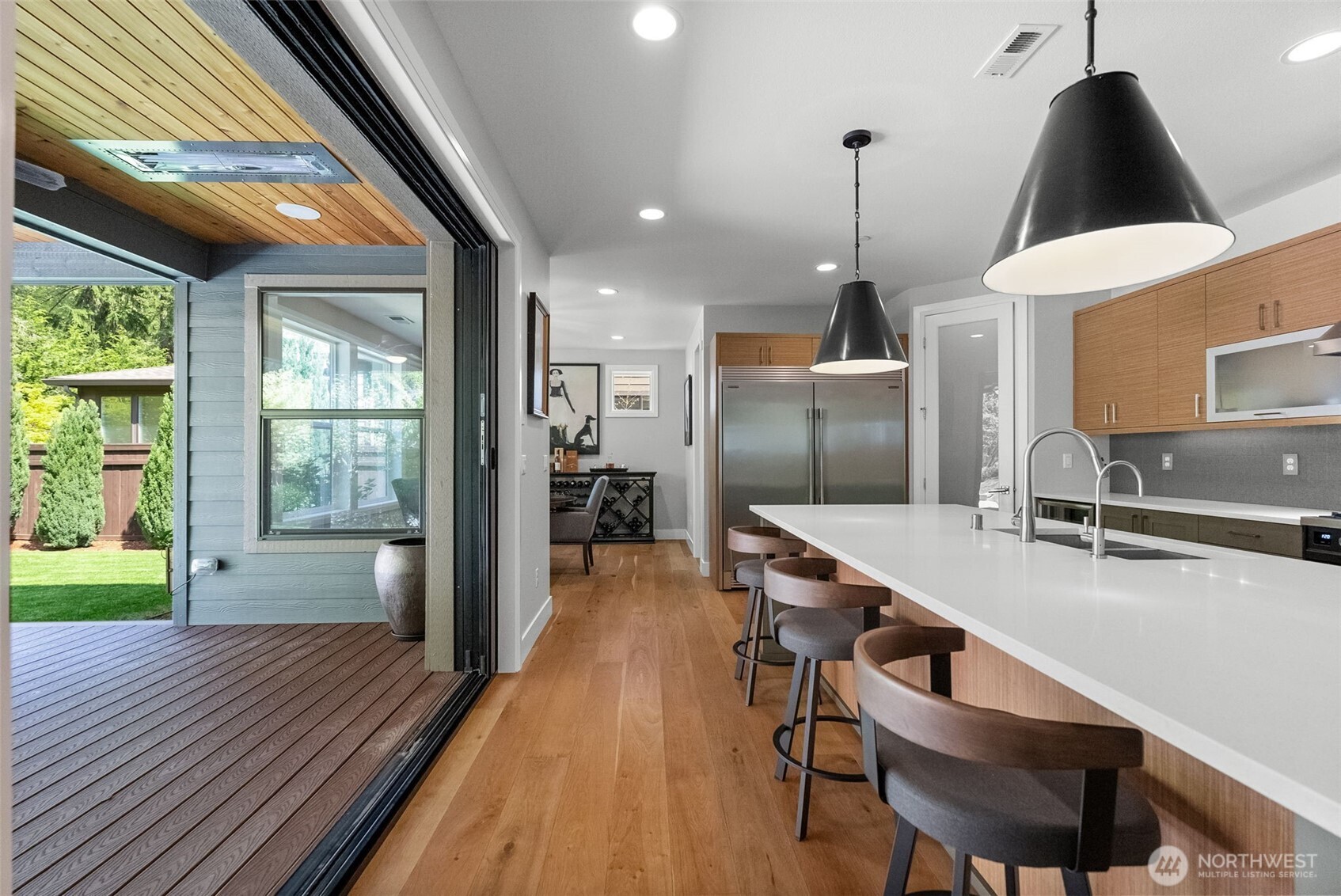 6565 Serenity Loop Gig Harbor, WA 98335 - Photo 12 of 40 a kitchen with stainless steel appliances a dining table chairs and wooden floor