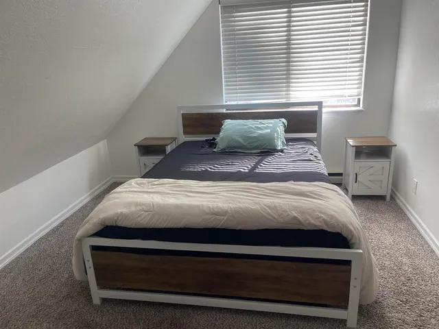 a bedroom with a bed and windows