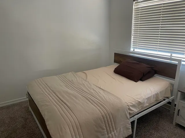 a bedroom with a bed and a window