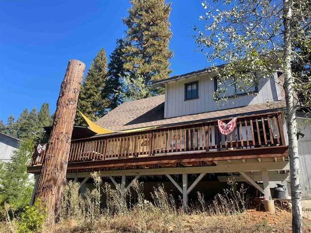 a view of a house with wooden deck and furniture