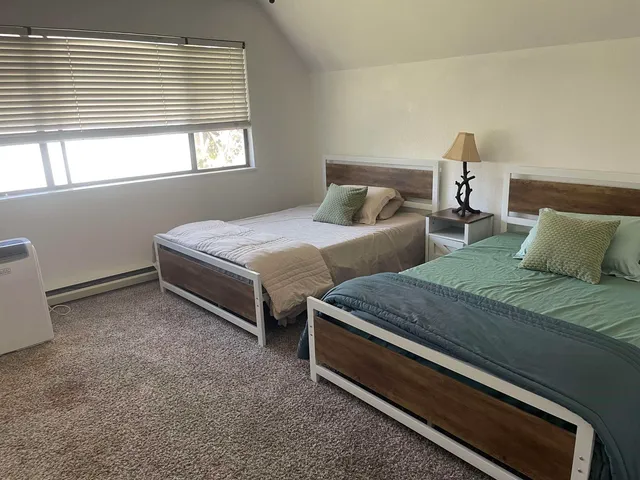 a bedroom with two beds and a window