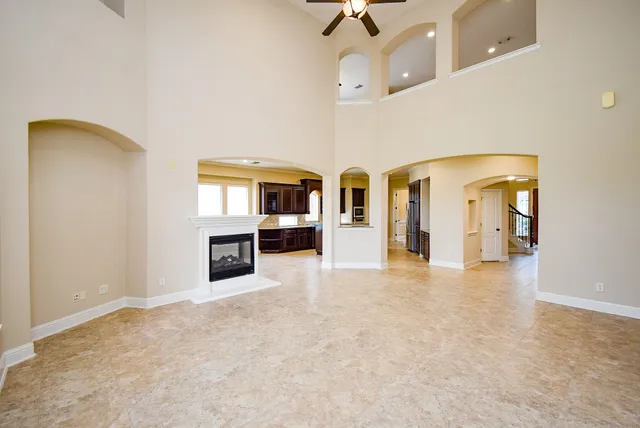 an empty room with windows and fireplace