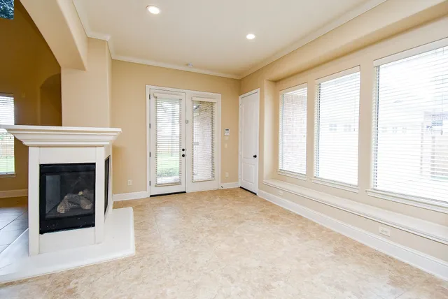 a view of an empty room with a fireplace and a window
