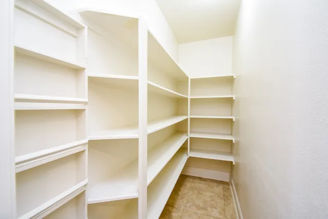 a view of walk in closet with empty racks