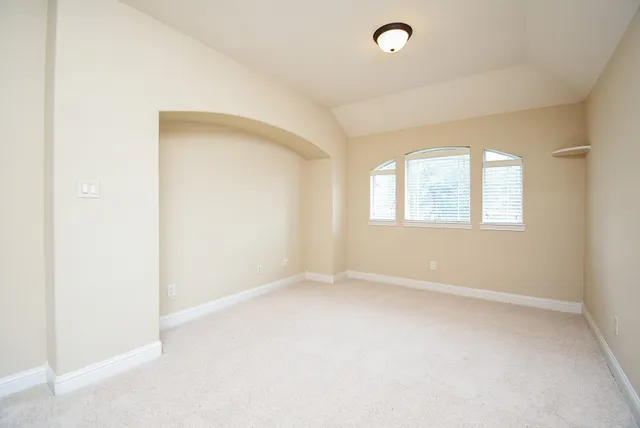an empty room with windows and closet