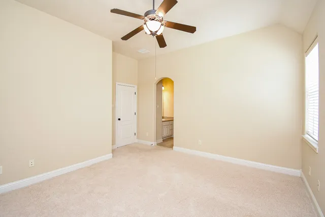 a view of a room with a ceiling fan and a window