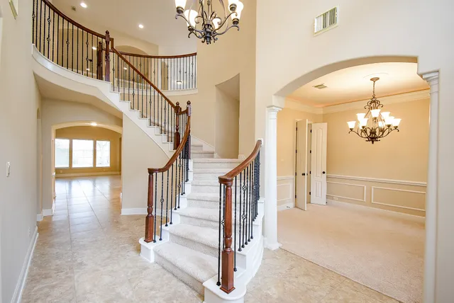 a view of a hallway with wooden floor and staircase