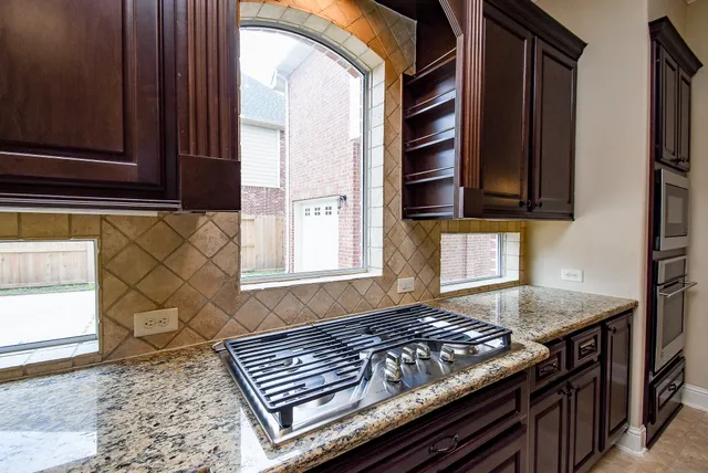 a kitchen with wooden cabinets and a stove top oven