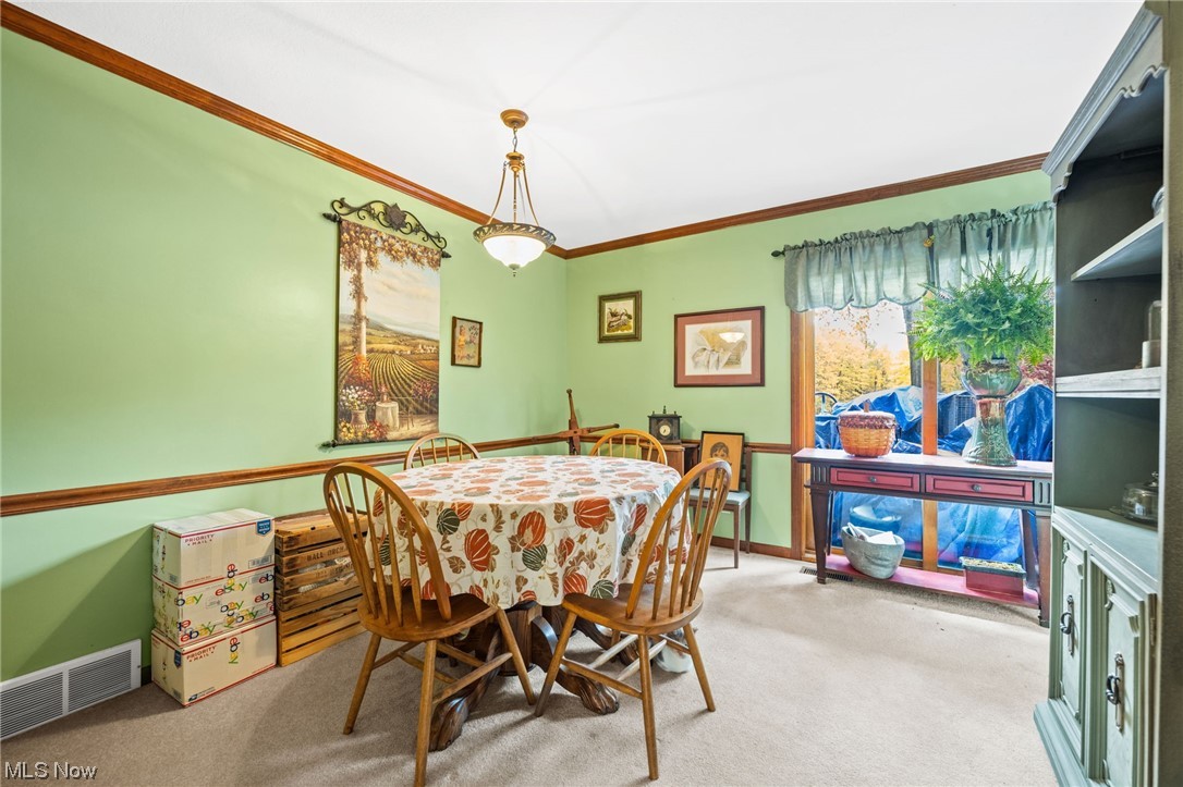 Dining area with crown molding and chair rail.