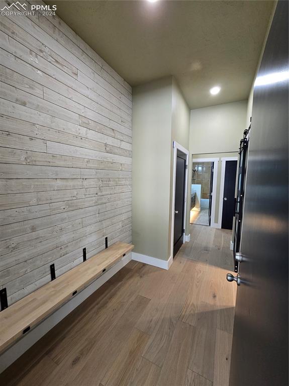 33036 Meadow Ridge Lane Trinidad, CO 81082 - Photo 25 of 50 Corridor with light wood-type flooring, a barn door into laundry, and wooden walls