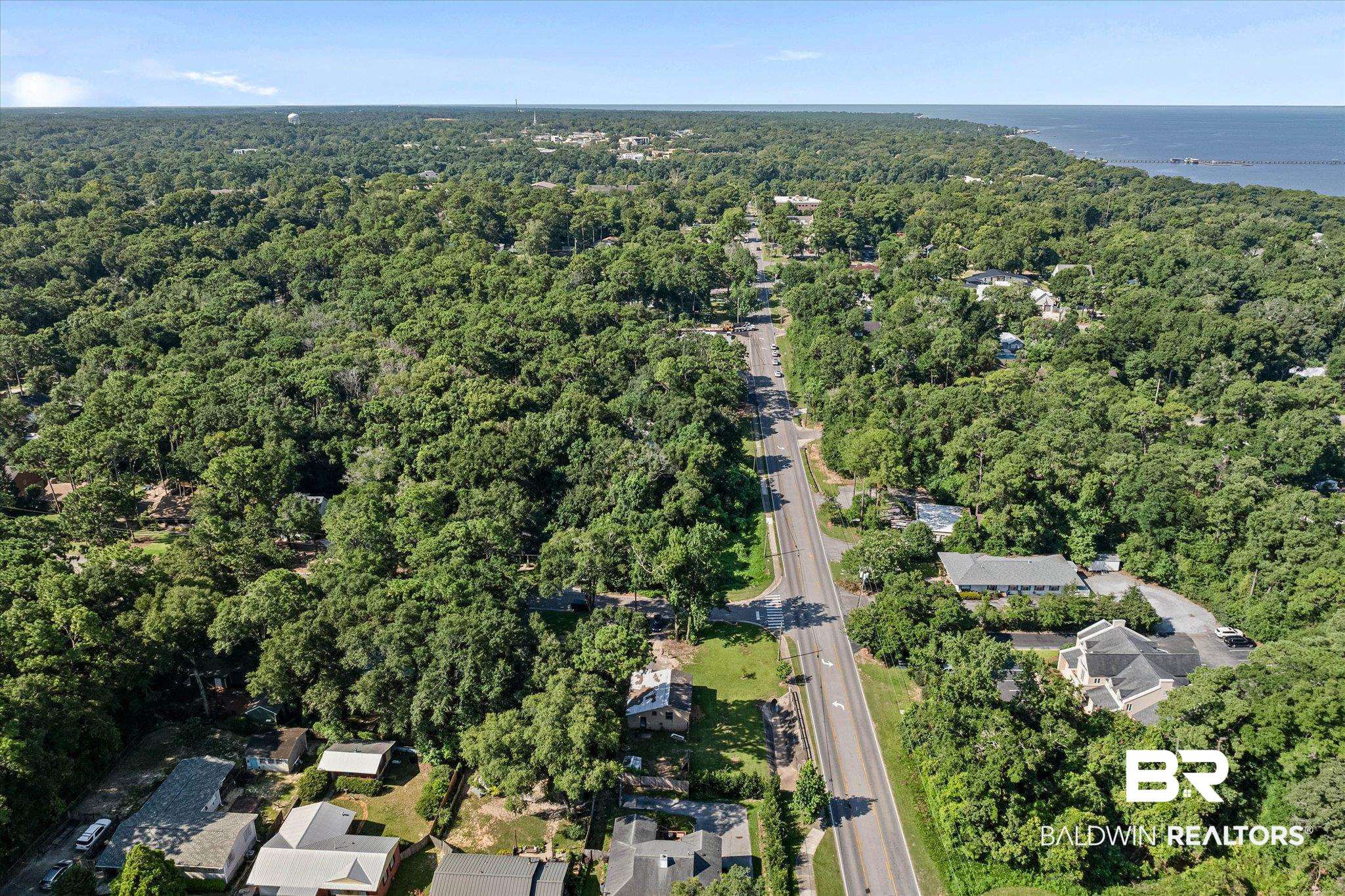 401 Frederick Avenue Fairhope, AL 36532 - Photo 24 of 36 Aerial perspective showcasing a dense tree canopy, a paved road, and distant water