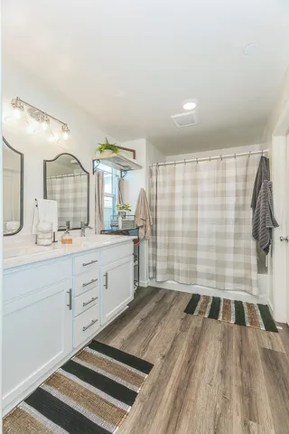 a spacious bathroom with a shower a sink and a mirror