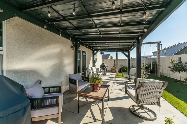a view of a patio with chairs and floor to ceiling window with wooden floor