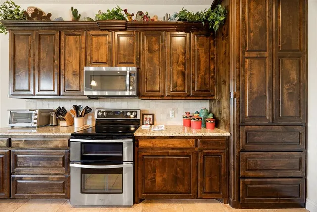 a kitchen with stainless steel appliances granite countertop a stove and cabinets