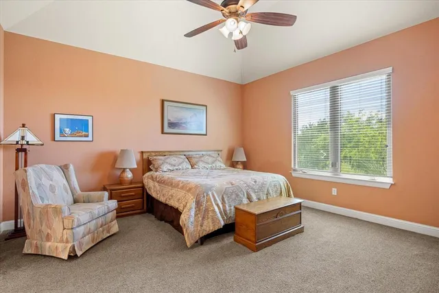 a spacious bedroom with a bed couch and window