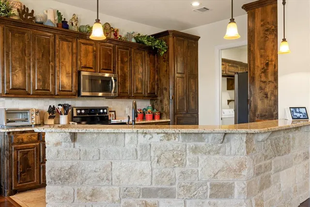 a view of a kitchen with stainless steel appliances granite countertop a stove top oven a sink and dishwasher