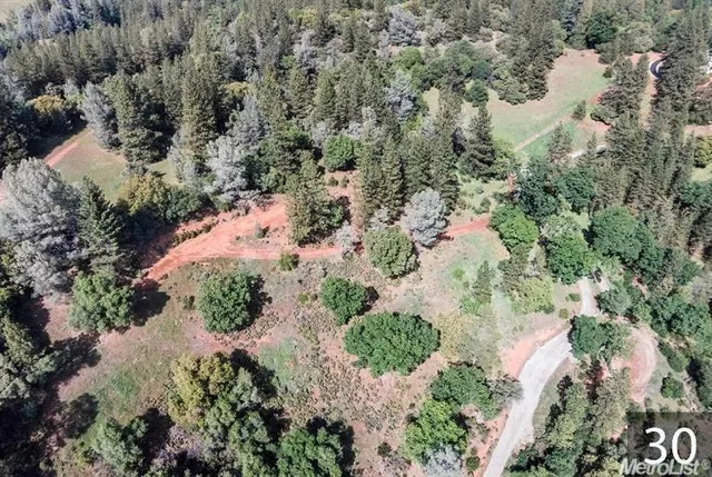 an aerial view of residential house with yard and outdoor seating