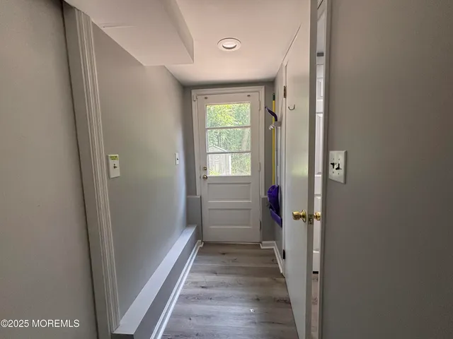 a view of a hallway with wooden floor and closet