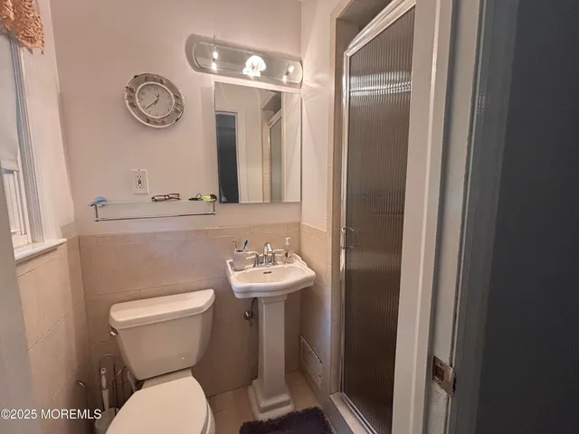 a bathroom with a toilet a sink and mirror