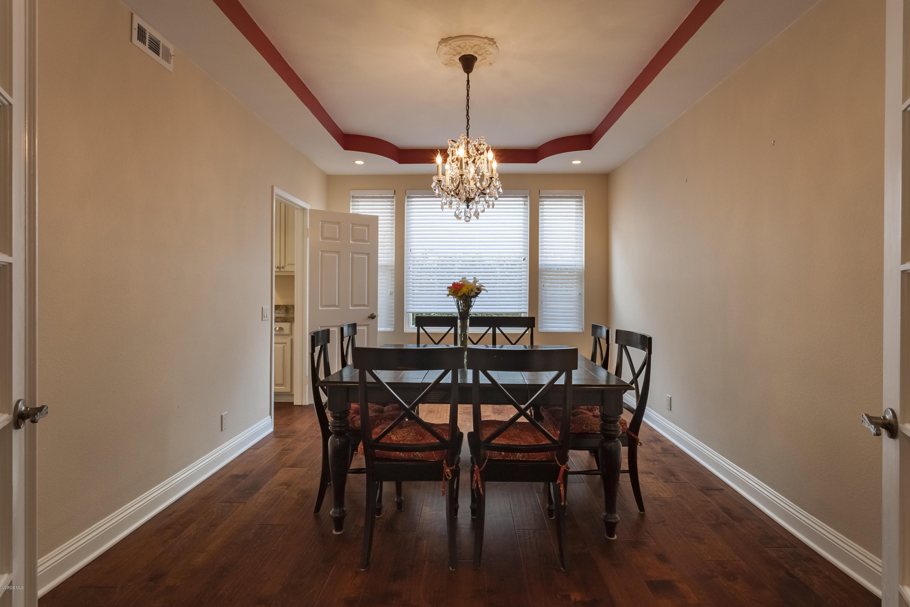 12142 Cherry Grove Street Moorpark, CA 93021 - Photo 12 of 36 a dining room with wooden floor a chandelier a wooden table and chairs