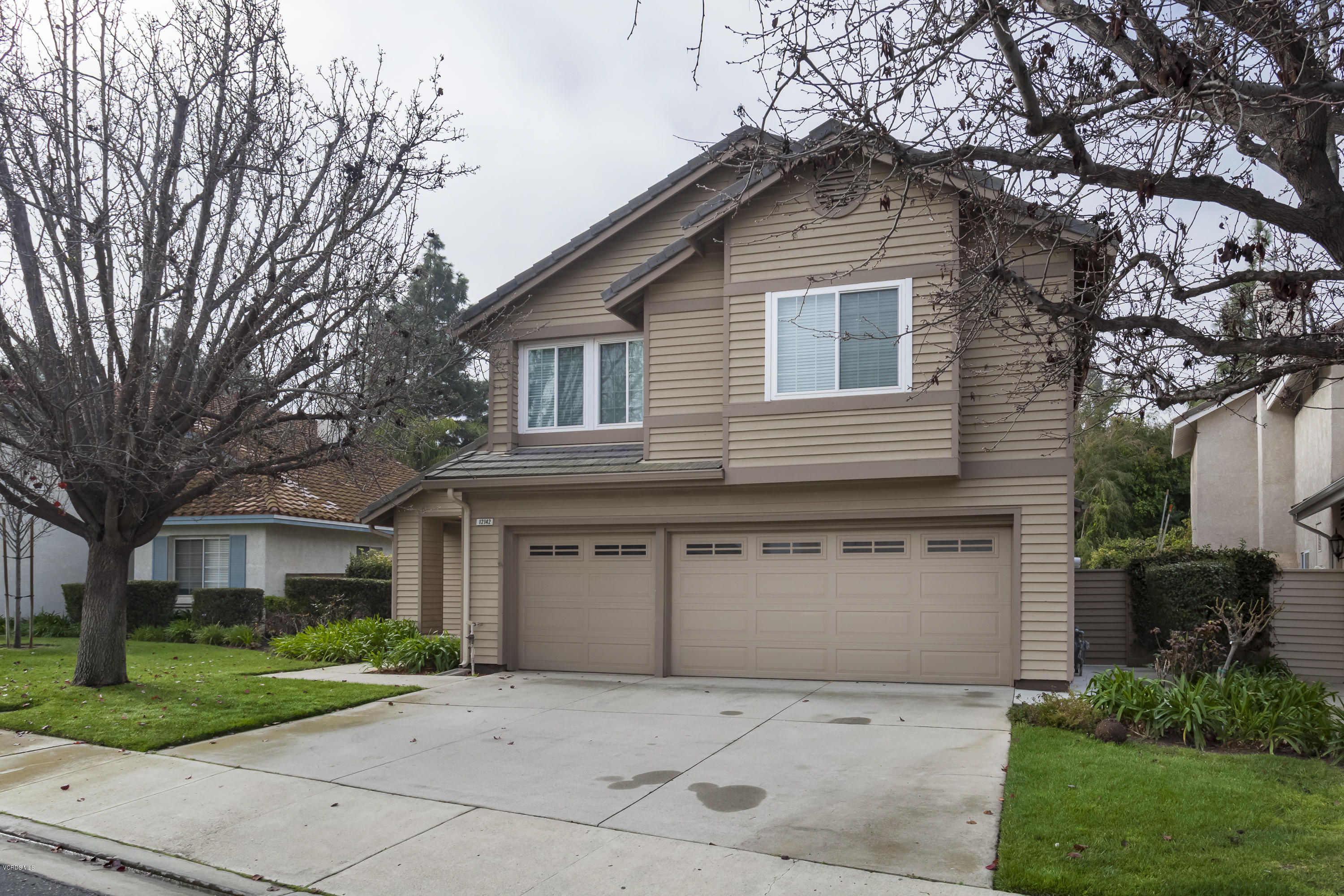 12142 Cherry Grove Street Moorpark, CA 93021 - Photo 25 of 36 a front view of a house with a yard and garage