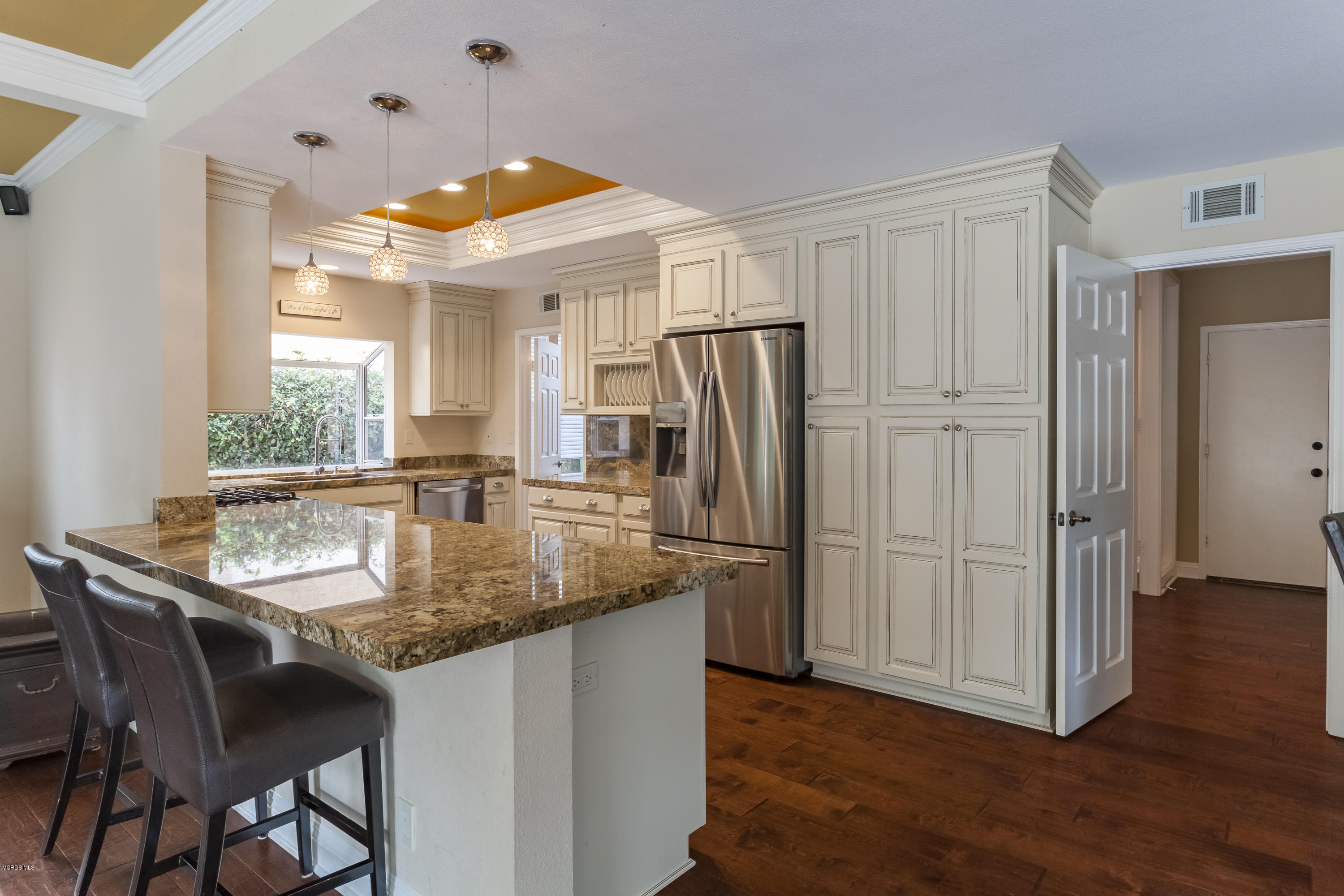 12142 Cherry Grove Street Moorpark, CA 93021 - Photo 7 of 36 a kitchen with stainless steel appliances granite countertop a table chairs and a refrigerator