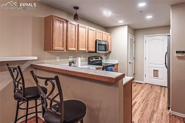 a kitchen that has a table chairs in it and wooden floors