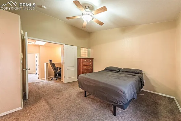 a bedroom with a bed a table and a chandelier
