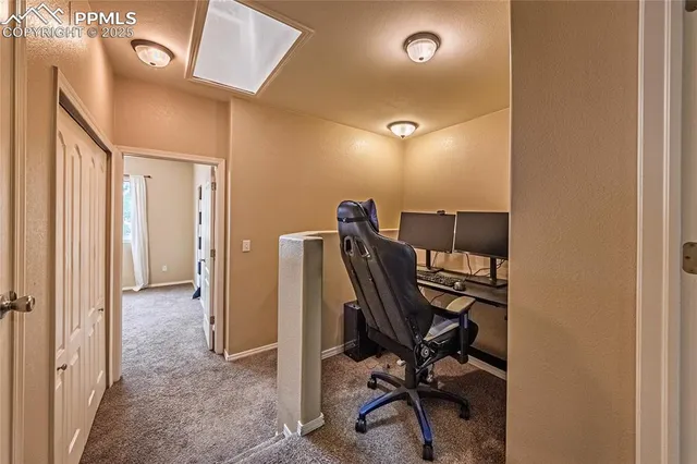 a view of a workspace with furniture and a window